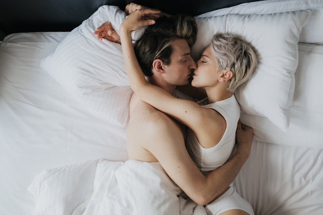 Man and woman kissing in bed