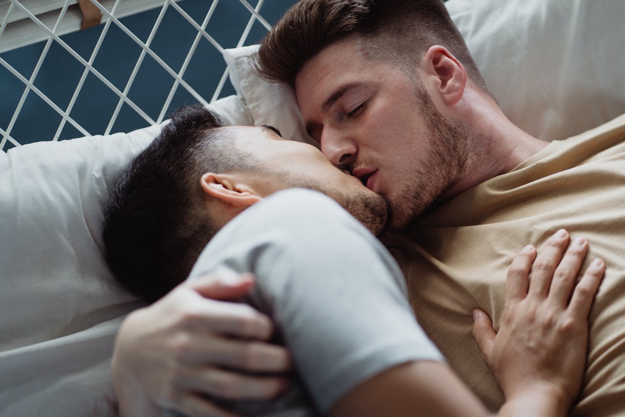 A couple kissing intimately in bed