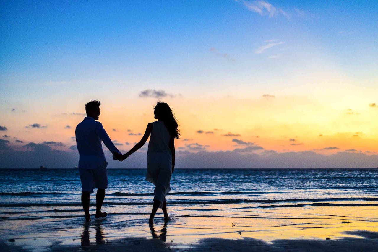 Silhouette of a couple on a beach backlit by the sunset